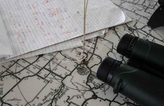 A pair of binoculars on a map next to a string line.